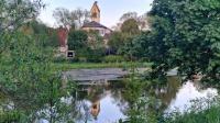 Spiegelbilder: Im schönen Donau-Dorf Pfohren spiegelt sich die katholische Kirche in der jungen, blauen Donau 