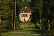Am Ende des Tunnels aus Bäumen im Baum-Fenster des Queen-Auguste-Victoria-Parks: Das Schlösschen